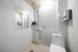 a white bathroom with a shower and a toilet at 호텔 휴 in Pup'yŏng-yŏk +20 photos