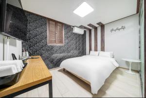 a bedroom with a white bed and a sink at 호텔 휴 in Pup'yŏng-yŏk