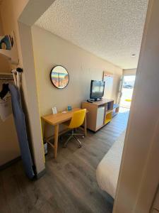 a room with a desk and a room with a bed and a television at Days Inn by Wyndham Kingman West in Kingman