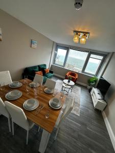 a dining room with a table and chairs and a living room at Stunning Sea View 2BR Flat Sleeps 5 Walk to Beach - Big Savings for Extended Stays - by Nestora Stays Ltd in Brighton & Hove