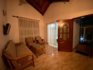 a living room with a couch and chairs and a door at CFR SkyLine in Katunayaka