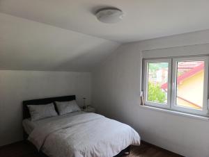 a white bedroom with a bed and a window at Zen Zone Trio in Foča +12 photos