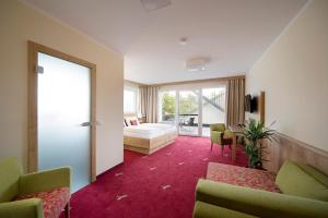 a hotel room with a bed and a couch and chairs at Landgasthof Hotel Rössle in Steinenkirch