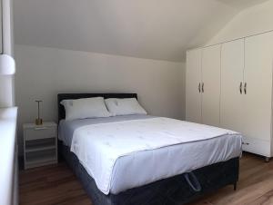 a bedroom with a large bed and white cabinets at Zen Zone Trio in Foča