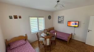 a living room with a table and a couch at Perućac - Apartman sa pogledom na jezero in Perućac