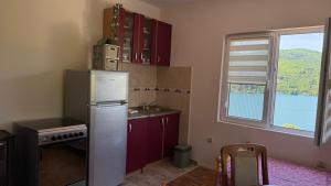a kitchen with a refrigerator and a window at Perućac - Apartman sa pogledom na jezero in Perućac