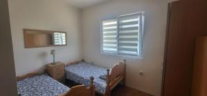 a bedroom with two twin beds and a window at Perućac - Apartman sa pogledom na jezero in Perućac