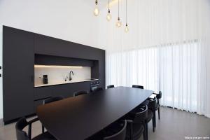 a dining room with a black table and chairs at Ville delle luci in Tefahot