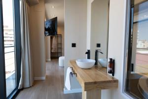 a bathroom with two sinks and a tv on a wall at Arena Málaga Suites in Málaga +3 photos