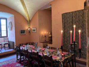 a dining room with a long table with red candles at Chateau d Albon - Catherine de Medicis in Saint-André-dʼApchon
