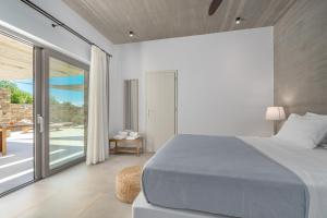a bedroom with a bed and a large window at Gray and Blue in Andros +63 photos