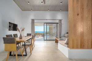 a dining room and living room with a table and chairs at Gray and Blue in Andros