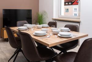 a wooden table with chairs and plates on it at Casa Materi Schweinfurt in Schweinfurt