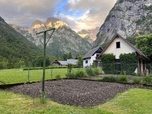 a house in a field with mountains in the background at Apartma 35 in Soča