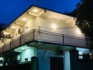 a building with a balcony with lights on it at Quench Inn in Ampara