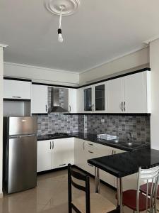a kitchen with a stainless steel refrigerator and a table at Lukova Center Sunset Apartments in Lukovë +29 photos