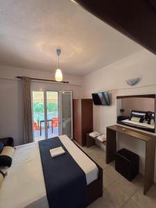 a bedroom with a bed and a desk and a television at Studio Nikol koutsoupia in Kokkino Nero