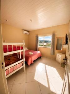 a bedroom with two bunk beds and a window at Pousada Arcanjo Rafael in Urubici