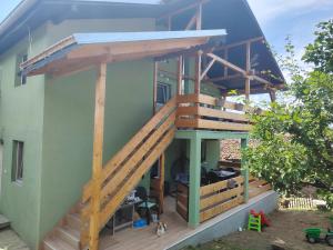 a house with a deck and a staircase at Apartman Dunav Plus in Donji Milanovac