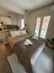 a bedroom with a large bed with towels on it at Kyma Boutique Suite in Nea Makri