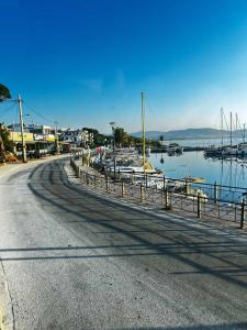 an empty road next to a marina with boats at Kyma Boutique Suite in Nea Makri