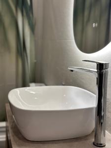 a bathroom sink with a faucet and a mirror at Kyma Boutique Suite in Nea Makri +31 photos