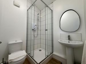 a bathroom with a shower and a toilet and a sink at The Den- Cosy Studio in Dowlais