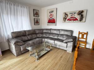 a living room with a couch and a glass table at La Villa Toledana in Cabañas de la Sagra