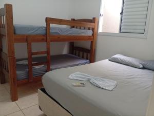 a room with two bunk beds and a bed with a remote control at Casa de férias Pôr do Sol 2 in Presidente Epitácio