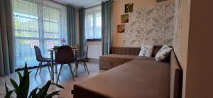 a living room with a couch and a table at Willa Jarmar - sala kominkowa z bilardem, wewnętrzny oraz zewnętrzny plac zabaw in Brenna