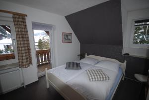 a bedroom with a white bed with two pillows on it at Pension Haus Am Hirschsprung in Willingen