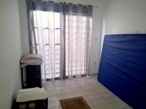 a room with a large window and a blue door at Hospedagem Aeroporto in Campinas