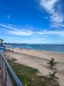 a beach with people in the water and a fence at Aconchego das Borboletas in Salvador +63 photos