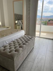 a bedroom with a bed and a large window at Torre Ginebra luxury laureles in Medellín