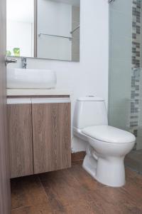 a bathroom with a white toilet and a sink at Torre Ginebra luxury laureles in Medellín +31 photos