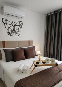 a bedroom with a bed with a table on it at Aconchego das Borboletas in Salvador