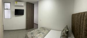 a hotel room with a bed and a television at Torre Ginebra luxury laureles in Medellín