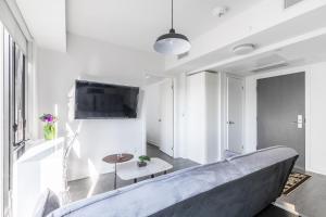 a living room with a couch and a tv at The Nobleton Suites - Yorkville in Toronto +7 photos