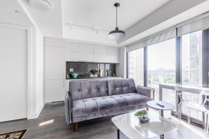 a living room with a couch and a table at The Nobleton Suites - Yorkville in Toronto