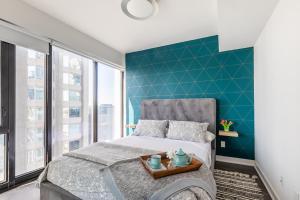 a bedroom with a bed and a blue accent wall at The Nobleton Suites - Yorkville in Toronto