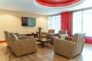 a waiting room with chairs and a flat screen tv at Hotel Alles Blau in Pelotas