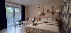 a bedroom with two beds and a large window at Willa Jarmar - sala kominkowa z bilardem, wewnętrzny oraz zewnętrzny plac zabaw in Brenna