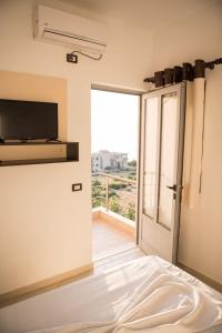 a room with a bed and a television and a door at Seaview Radhime in Vlorë +16 photos