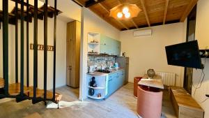 a living room with a tv and a room with a table at Chalet Kvariati in Kvariat'i