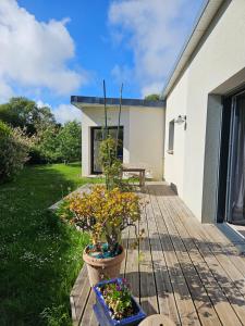 a wooden deck with a potted plant on it at Chambre privée proche GR & Véloroute in Plougonvelin