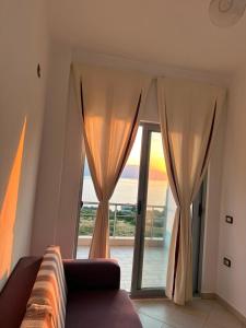 a living room with a couch and a large window at Seaview Radhime in Vlorë