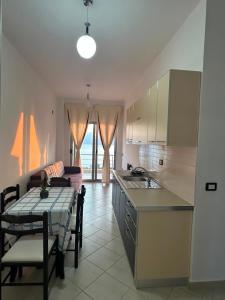 a kitchen with a table and a kitchen with a dining room at Seaview Radhime in Vlorë