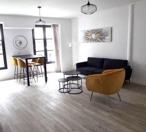 a living room with a couch and a table and chairs at Klass Loft Kemperle in Quimperlé
