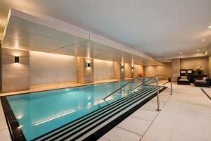 a large swimming pool in a building with a lobby at The Nobleton Suites - Yorkville in Toronto