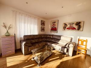 a living room with a couch and a glass table at La Villa Toledana in Cabañas de la Sagra